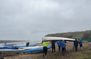 Tynemouth Rowing Club Tynemouth Rowing Club group of people carrying a white boat on the beach