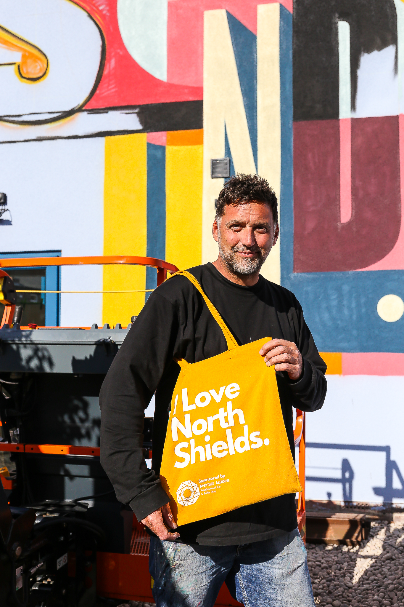 I Beg That Sound - Ricky Also’s wall mural for Elevation 8 Ricky featuring I Love North Shields tote bag. Photo by Wayne Bordoli